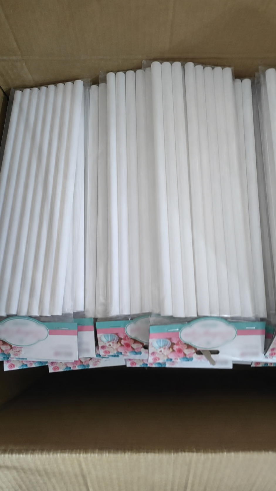 White cake dowels prepared with custom printed hang-card packing